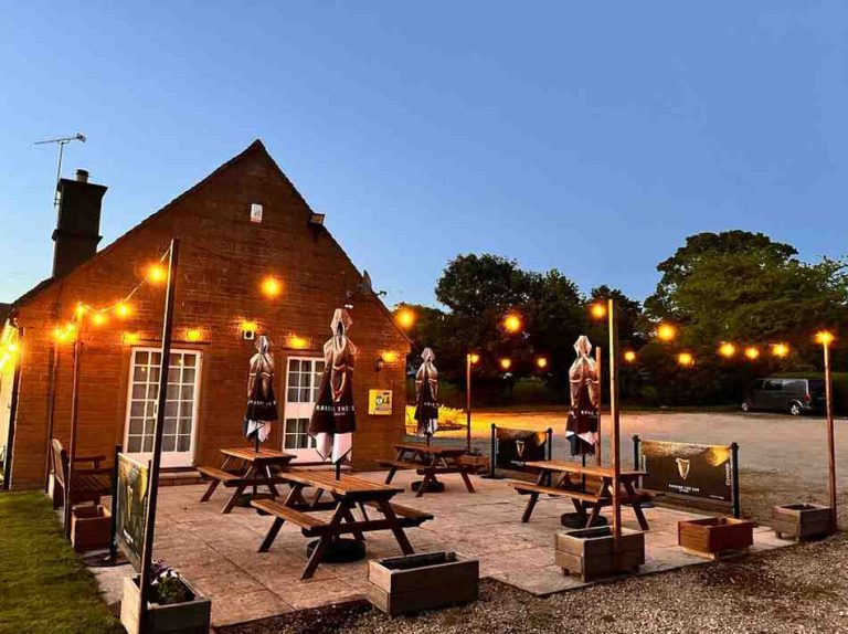 Stanton club garden with benches and umbrellas-with-lights-on